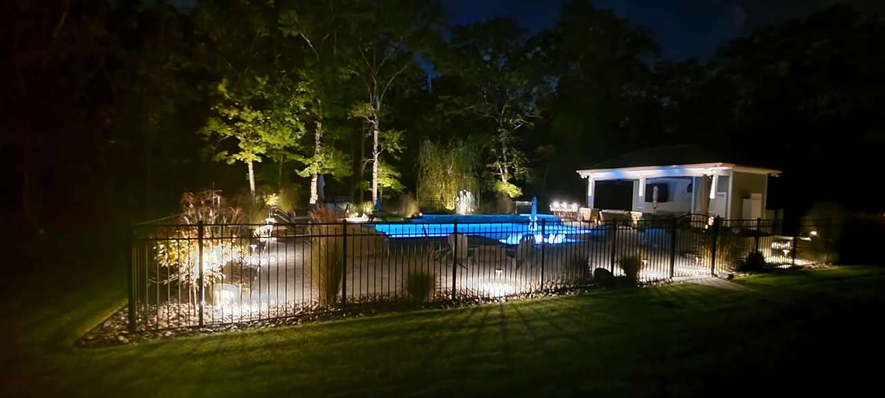 Pool and gazebo lit with warm landscape lighting